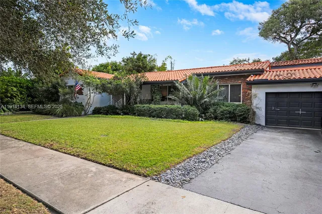 a view of swimming pool with lawn chairs and large trees