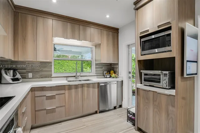 a kitchen with stainless steel appliances a stove sink microwave and cabinets