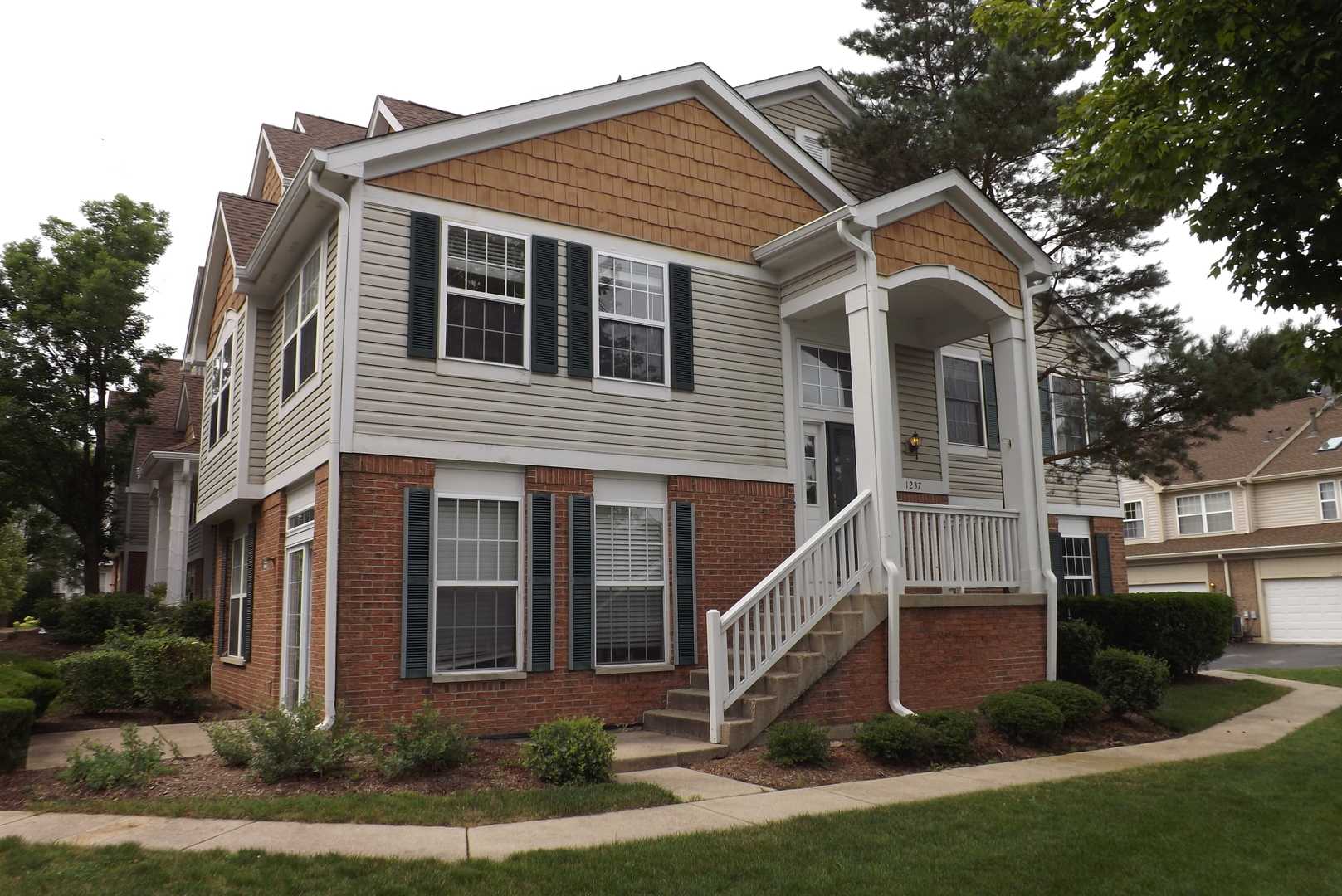a view of a house with brick walls and a yard with plants
