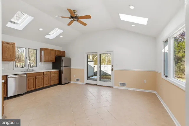 a large kitchen with lot of cabinets and outdoor space