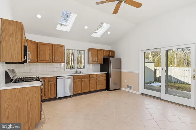 a kitchen with stainless steel appliances granite countertop a stove a sink and a refrigerator