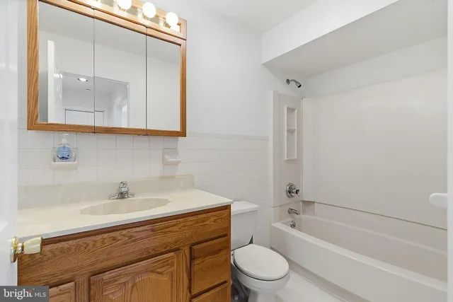 a bathroom with a sink a mirror a toilet and bathtub