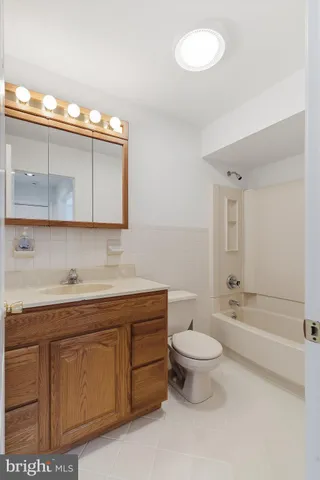 a bathroom with a granite countertop toilet sink and mirror
