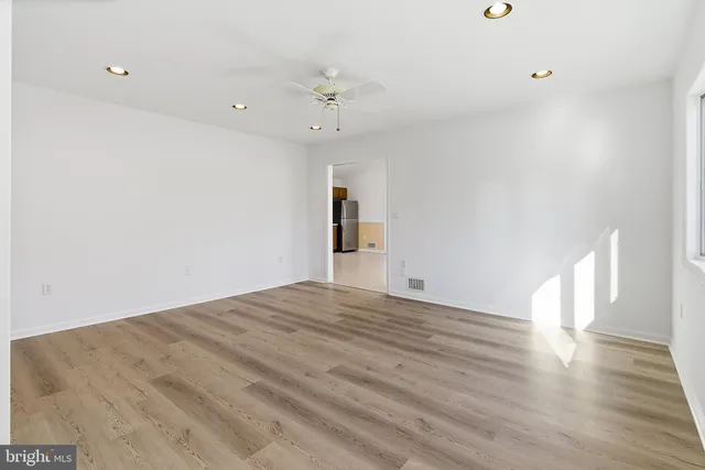 a view of empty room with wooden floor