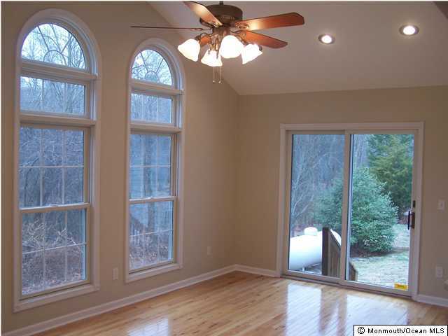 177 Thompson Bridge Road Jackson, NJ 08527 - Photo 2 of 3 an empty room with wooden floor fan and windows