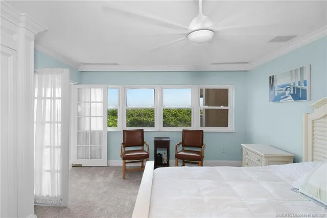 a bedroom with furniture and large windows