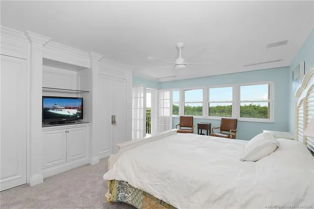 a large bedroom with a bed and large window