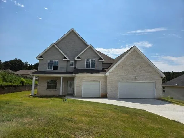 a front view of a house with a garden and yard