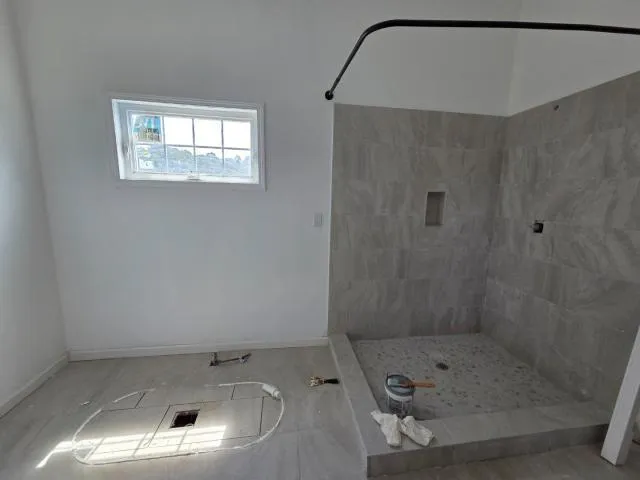 a bathroom with a sink a window and a shower
