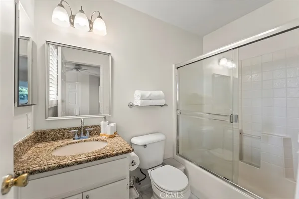 a bathroom with a granite countertop sink toilet and shower
