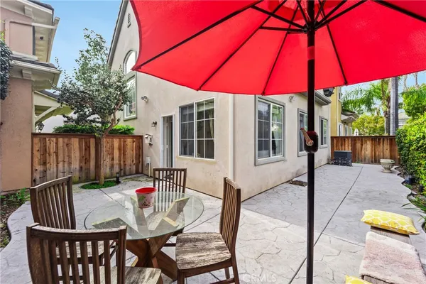 a patio with a table and chairs under an umbrella