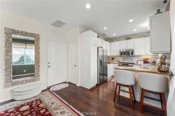 a kitchen with a table chairs refrigerator and cabinets