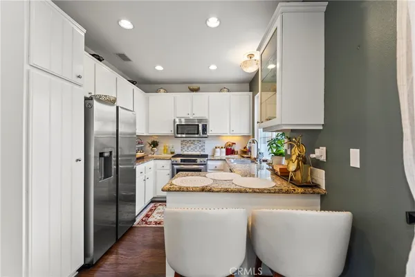 a kitchen with kitchen island stainless steel appliances a refrigerator a stove a sink and a cabinets