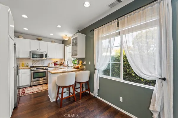 a kitchen with a table chairs refrigerator and cabinets