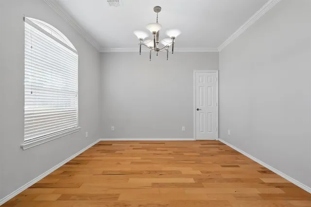 a view of wooden floor and chandelier fan in a room