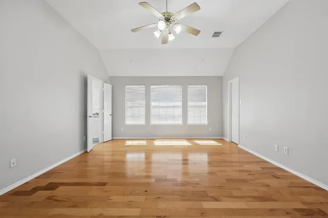 a view of an empty room with window and a kitchen