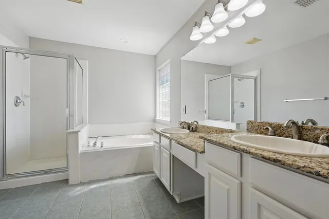 a bathroom with a granite countertop sink a large mirror and a bathtub
