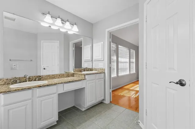 a bathroom with a granite countertop sink a mirror and a bathtub