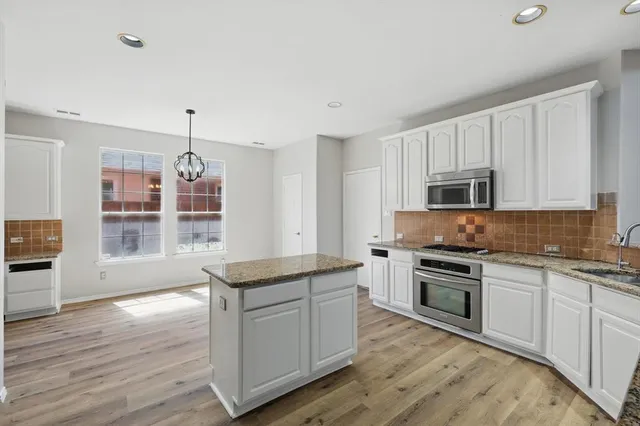 a kitchen with granite countertop white cabinets and appliances