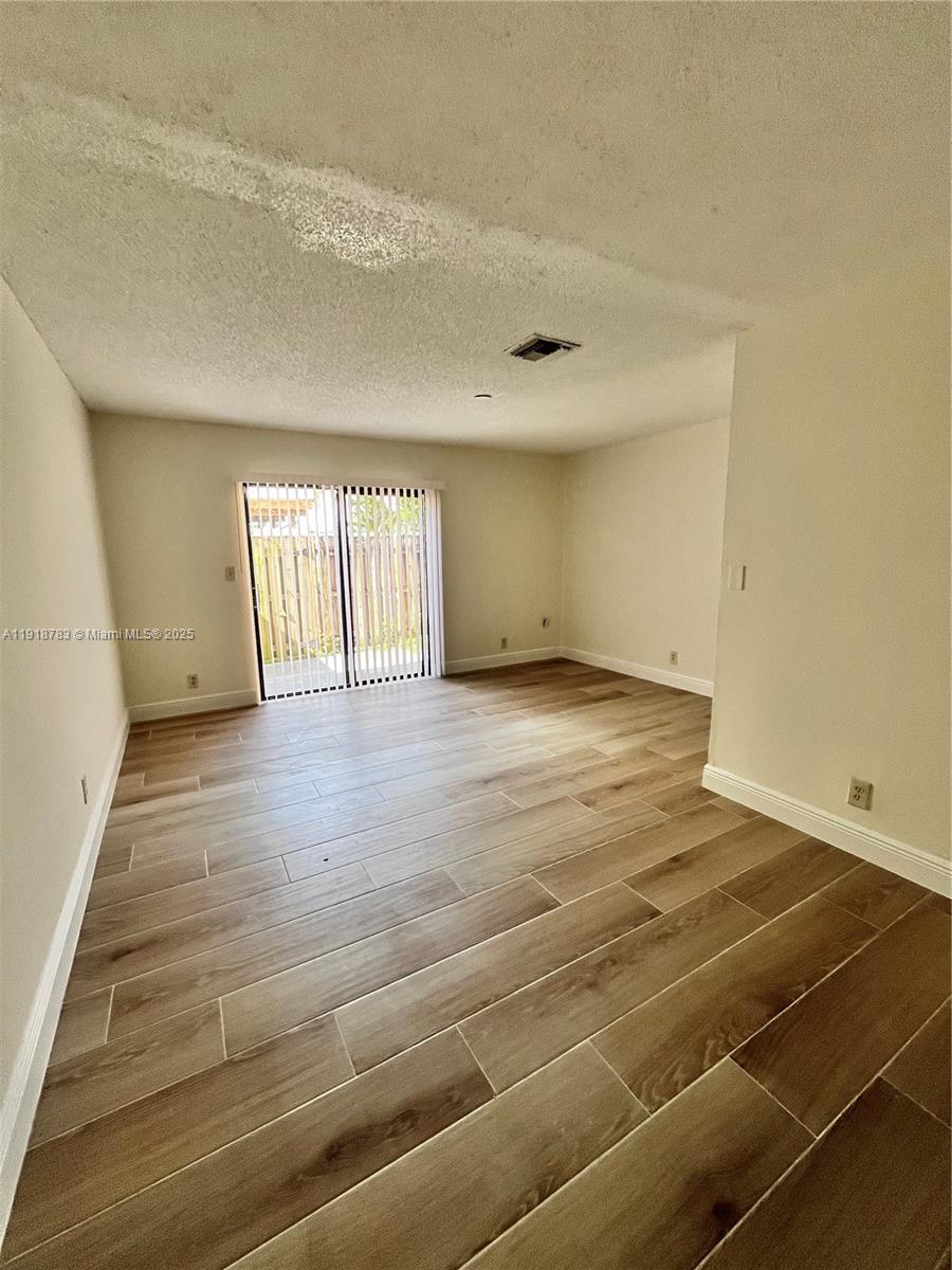 3281 East Golf Boulevard, Unit 12 Pompano Beach, FL 33064 - Photo 13 of 21 a view of an empty room with wooden floor and a window