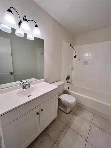 a bathroom with a toilet a sink a mirror and shower