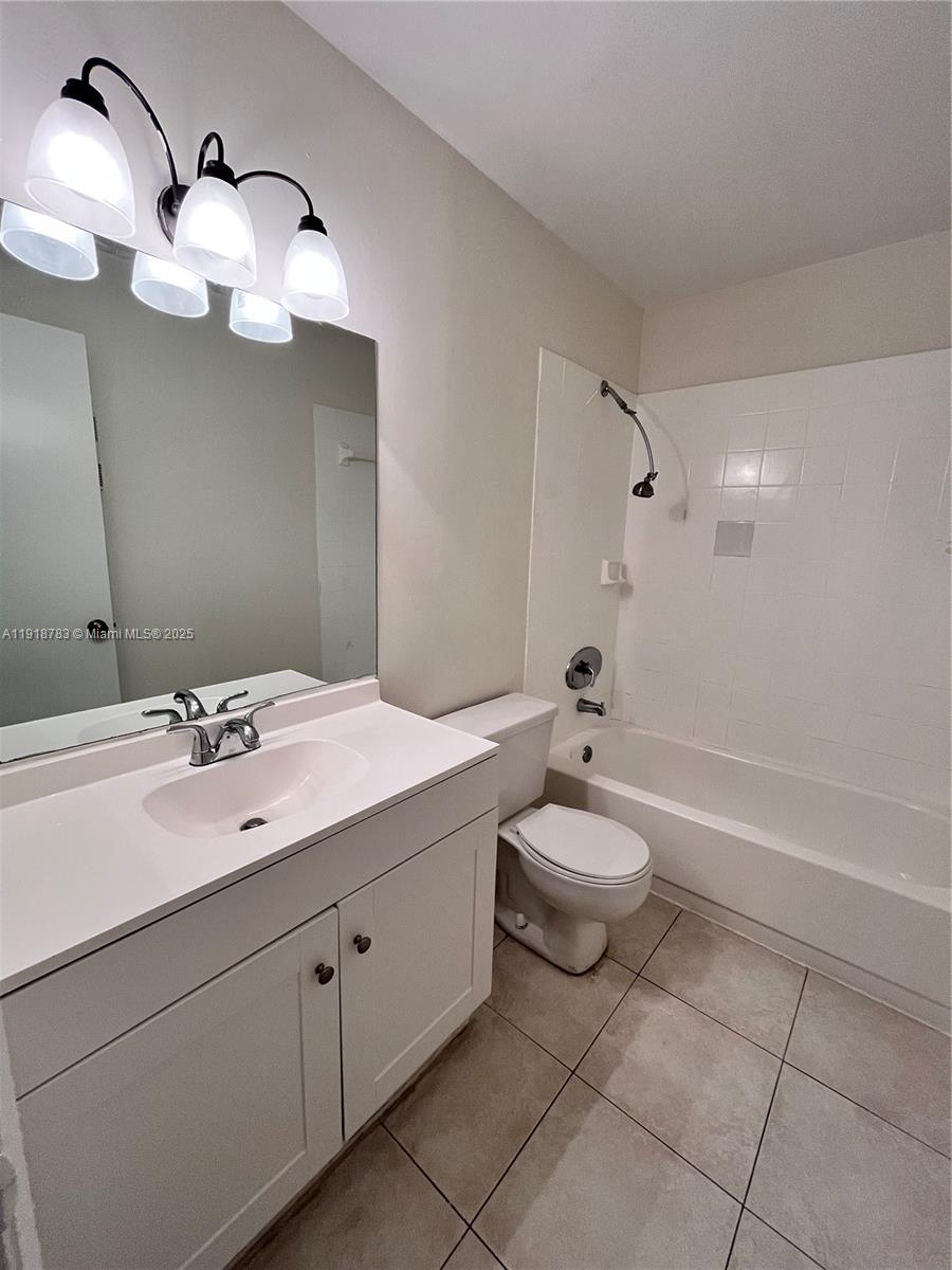 3281 East Golf Boulevard, Unit 12 Pompano Beach, FL 33064 - Photo 15 of 21 a bathroom with a toilet a sink a mirror and shower