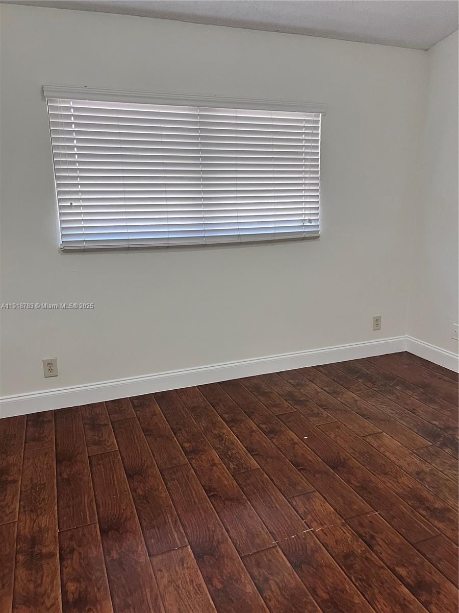 3281 East Golf Boulevard, Unit 12 Pompano Beach, FL 33064 - Photo 16 of 21 a view of a room with wooden floor and a window