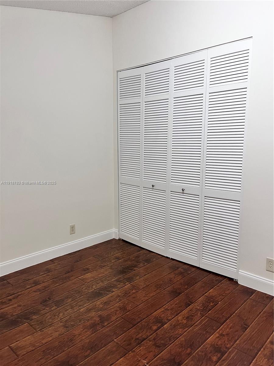 3281 East Golf Boulevard, Unit 12 Pompano Beach, FL 33064 - Photo 17 of 21 an empty room with wooden floor