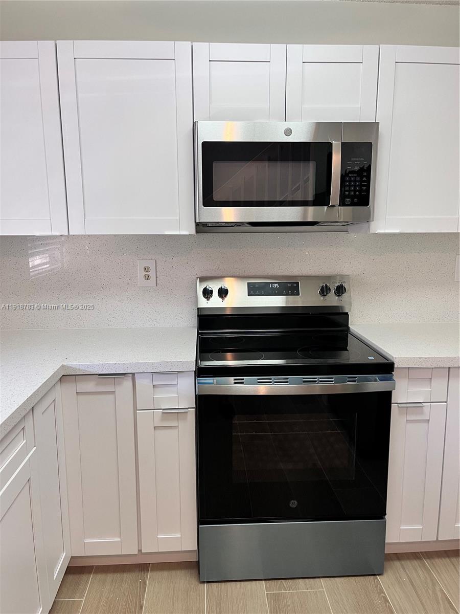 3281 East Golf Boulevard, Unit 12 Pompano Beach, FL 33064 - Photo 2 of 21 a kitchen with stainless steel appliances granite countertop a stove microwave and oven