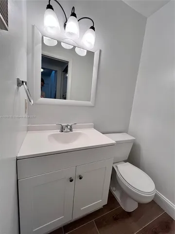 a bathroom with a sink a toilet and mirror