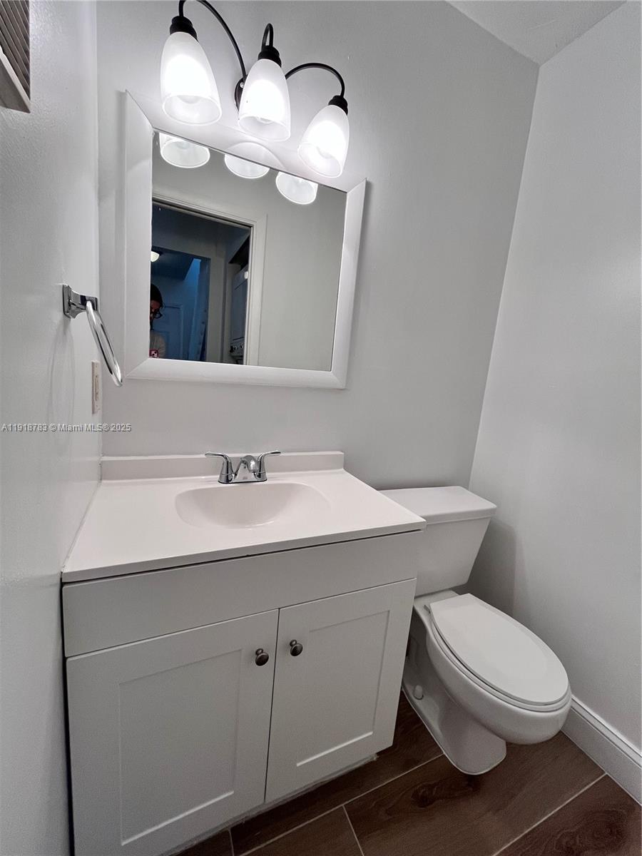3281 East Golf Boulevard, Unit 12 Pompano Beach, FL 33064 - Photo 7 of 21 a bathroom with a sink a toilet and mirror
