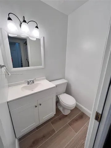 a bathroom with a toilet a sink and mirror