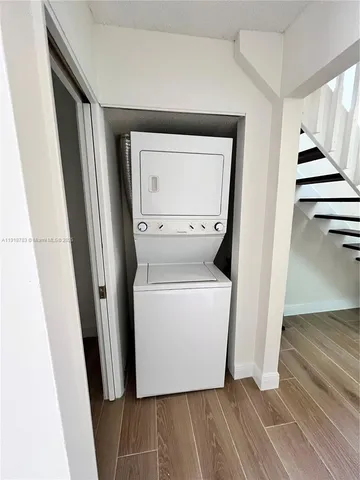 a utility room with wooden floor washer and dryer