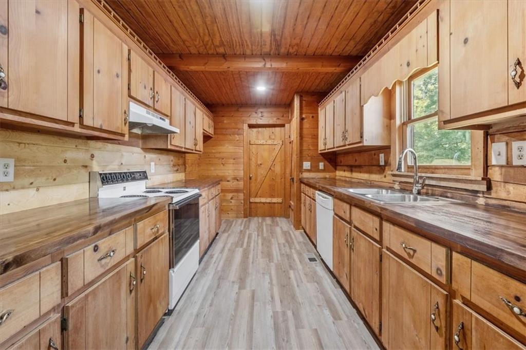 910 Brushtown Road Cisco, GA 30708 - Photo 16 of 30 a kitchen with stainless steel appliances granite countertop a sink a stove and cabinets with wooden floor