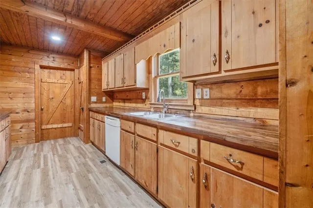 a kitchen with granite countertop wooden cabinets a sink and dishwasher