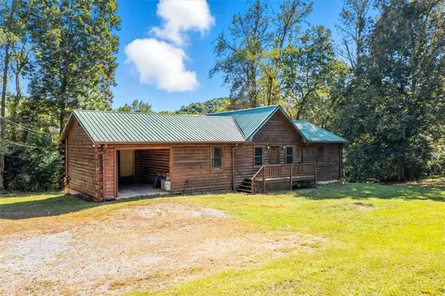 a view of a house with a yard and wooden fence