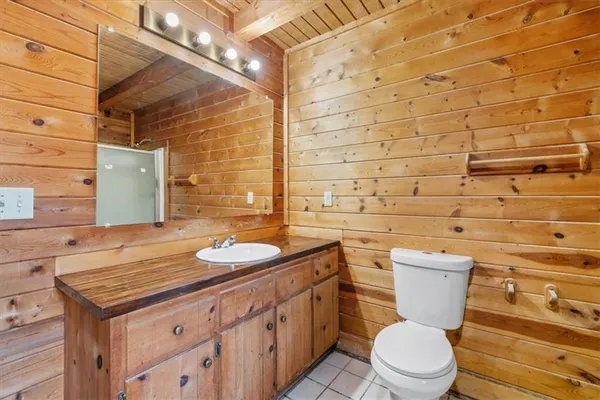 a bathroom with a granite countertop toilet sink and mirror