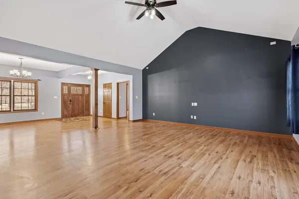 a view of a hallway with wooden floor and cabinet