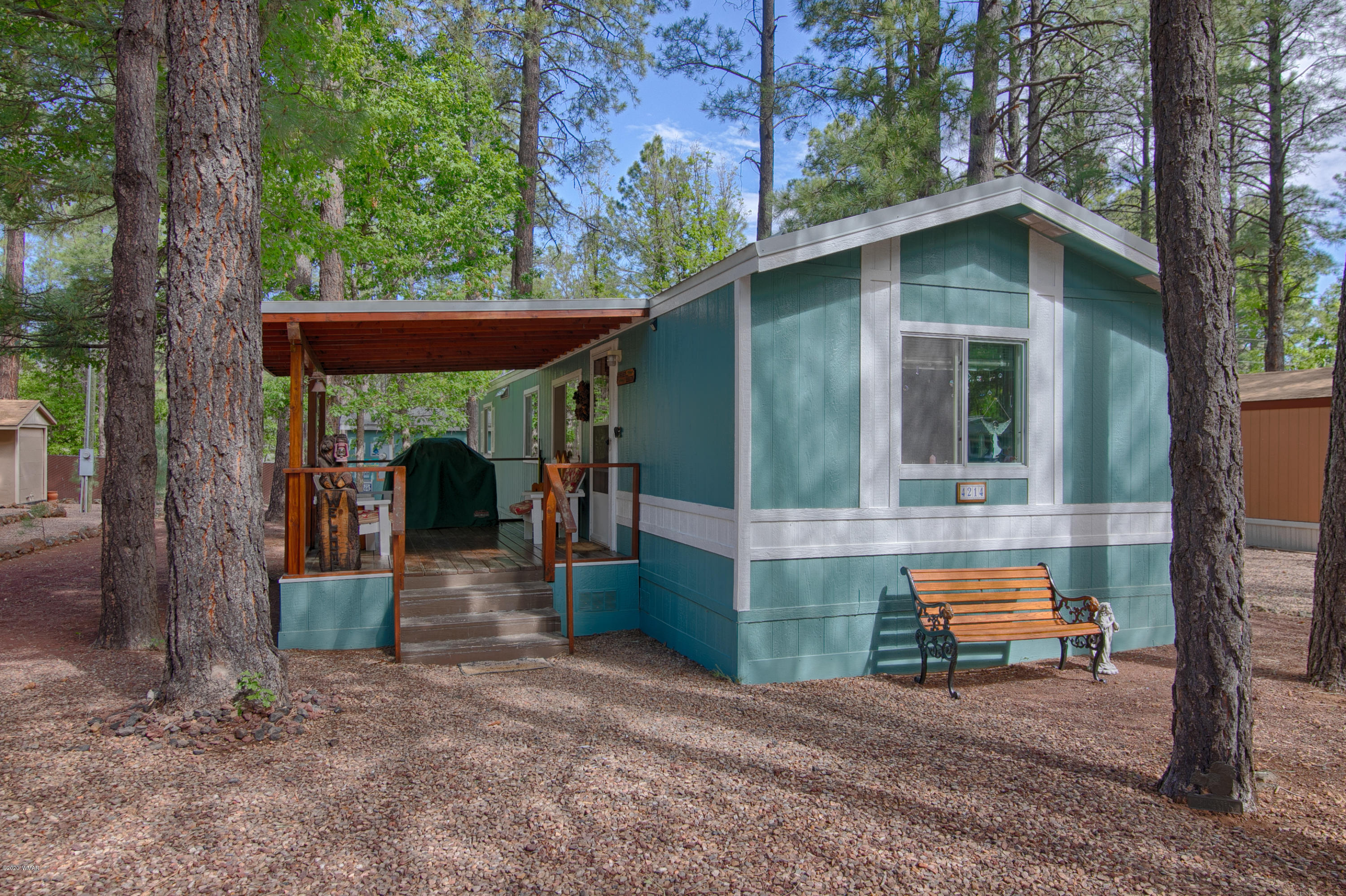 4214 West Blue Ridge Loop Pinetop, AZ 85935 - Photo 3 of 18 a backyard of a house with barbeque oven fire pit table and chairs