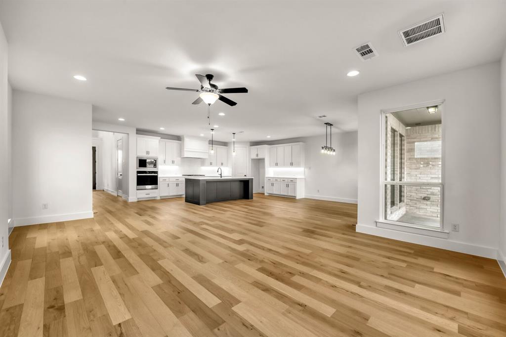 Open-concept living area with wood-finish flooring, recessed lighting, and a modern ceiling fan