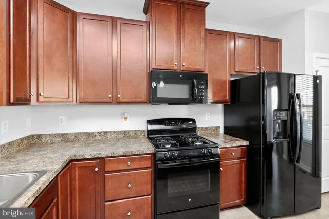 a kitchen with stainless steel appliances granite countertop a refrigerator stove and sink