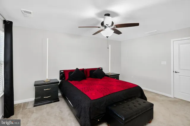 a bedroom with a bed and a flat tv screen on dresser