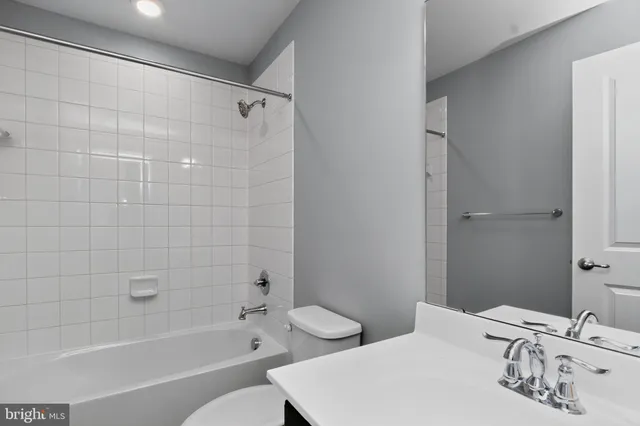 a bathroom with a granite countertop sink and a toilet