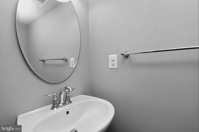 a bathroom with a sink a large mirror and a window