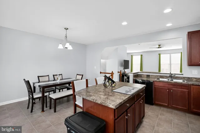 a kitchen with a stove a sink a dining table and chairs