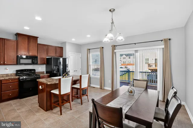 a view of a dining room with furniture a kitchen and chandelier