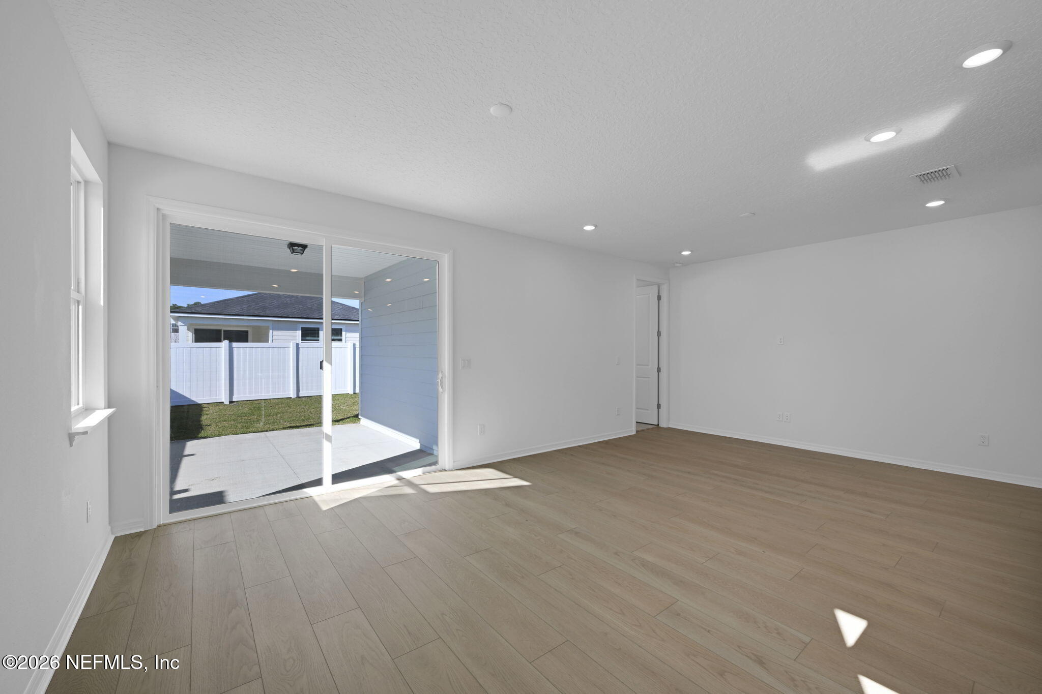 1749 Mickey Way Middleburg, FL 32068 - Photo 10 of 25 an empty room with wooden floor and entrance to ceiling window