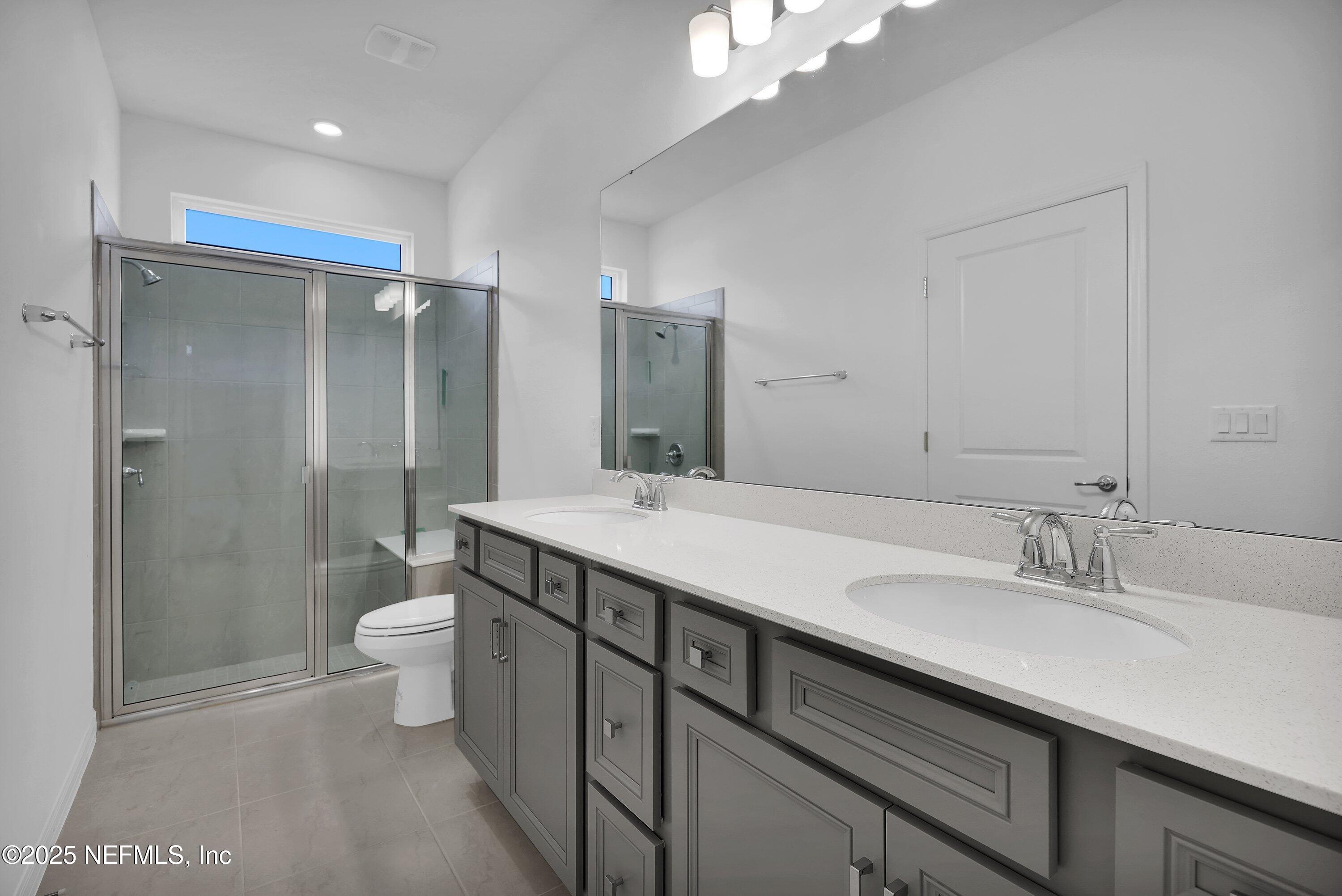 1749 Mickey Way Middleburg, FL 32068 - Photo 16 of 23 a bathroom with a double vanity sink toilet and shower