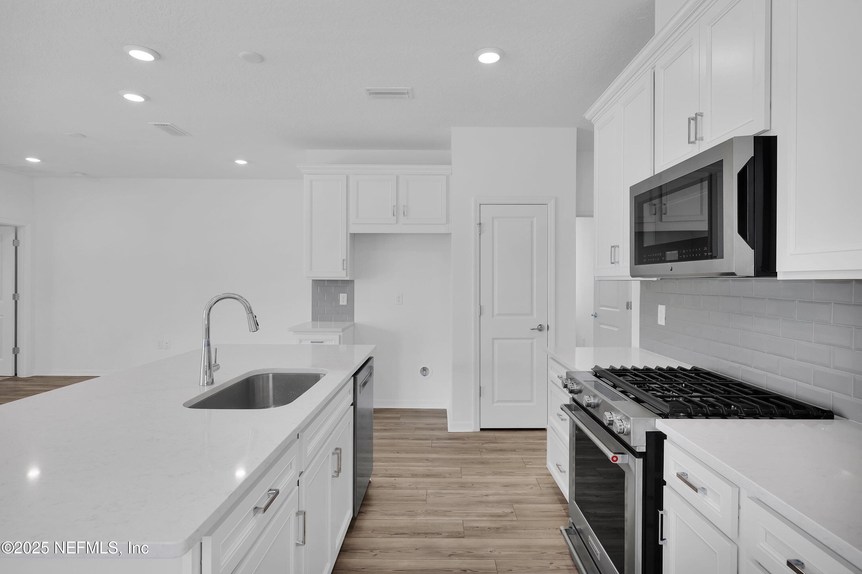 1749 Mickey Way Middleburg, FL 32068 - Photo 7 of 23 a kitchen with stainless steel appliances granite countertop a sink stove and refrigerator