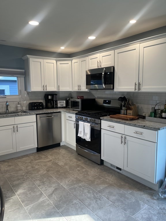 239 Plumtree Road Springfield, MA 01118 - Photo 5 of 14 a kitchen with a sink white cabinets and white appliances